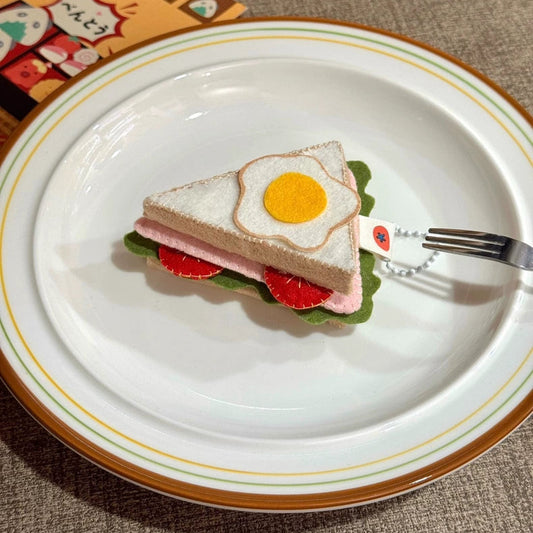 Toy sandwich with an egg on a plate with a fork